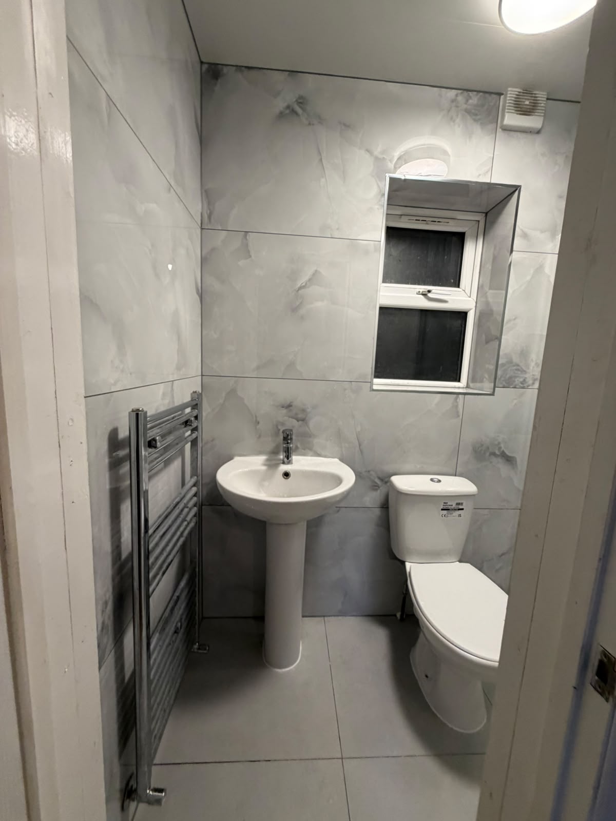 Bathroom basin, toilet and heated towel rail after installation